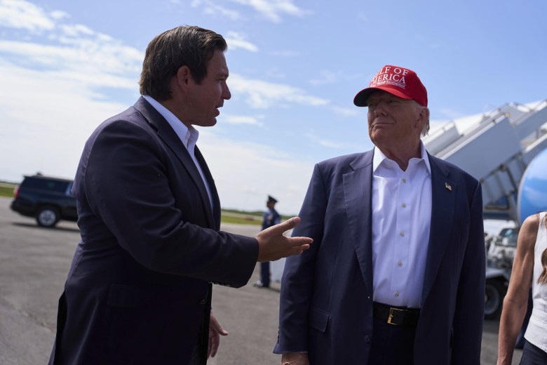 President Donald Trump listens as Florida Gov. Ron DeSantis speaks with reporters in July 2025. DeSantis’s takeover of New College previewed the kind of political control Trump is now trying to impose on universities nationwide.