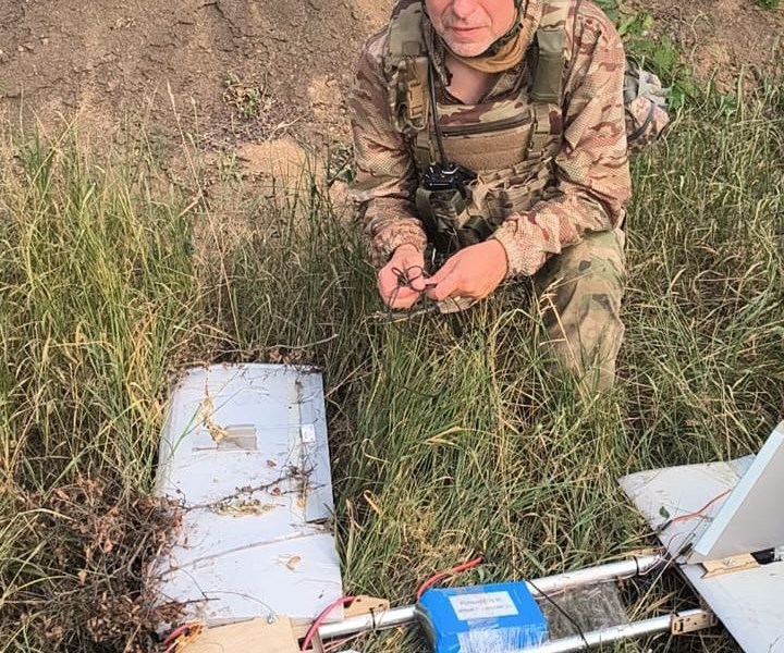 An officer from the Specter Battalion of the 54th Separate Mechanized Brigade demines a downed Russian drone near the eastern front in Ukraine.